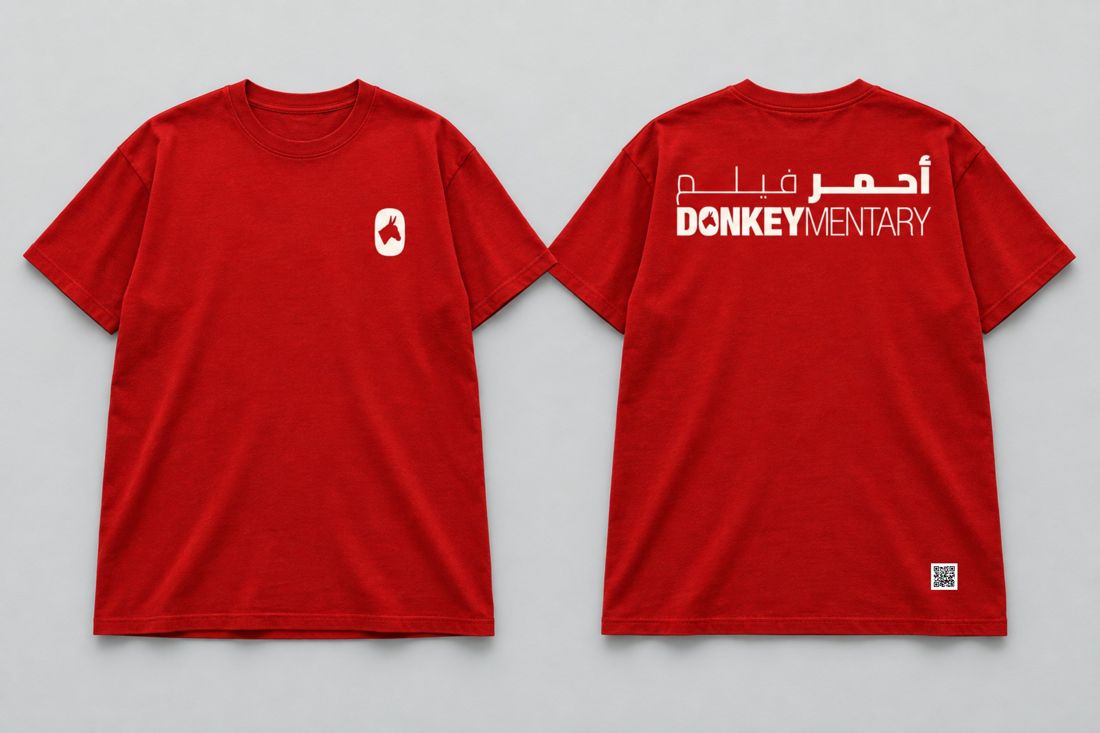 Red T-shirt, front and back: warm-white emblem and bilingual title.